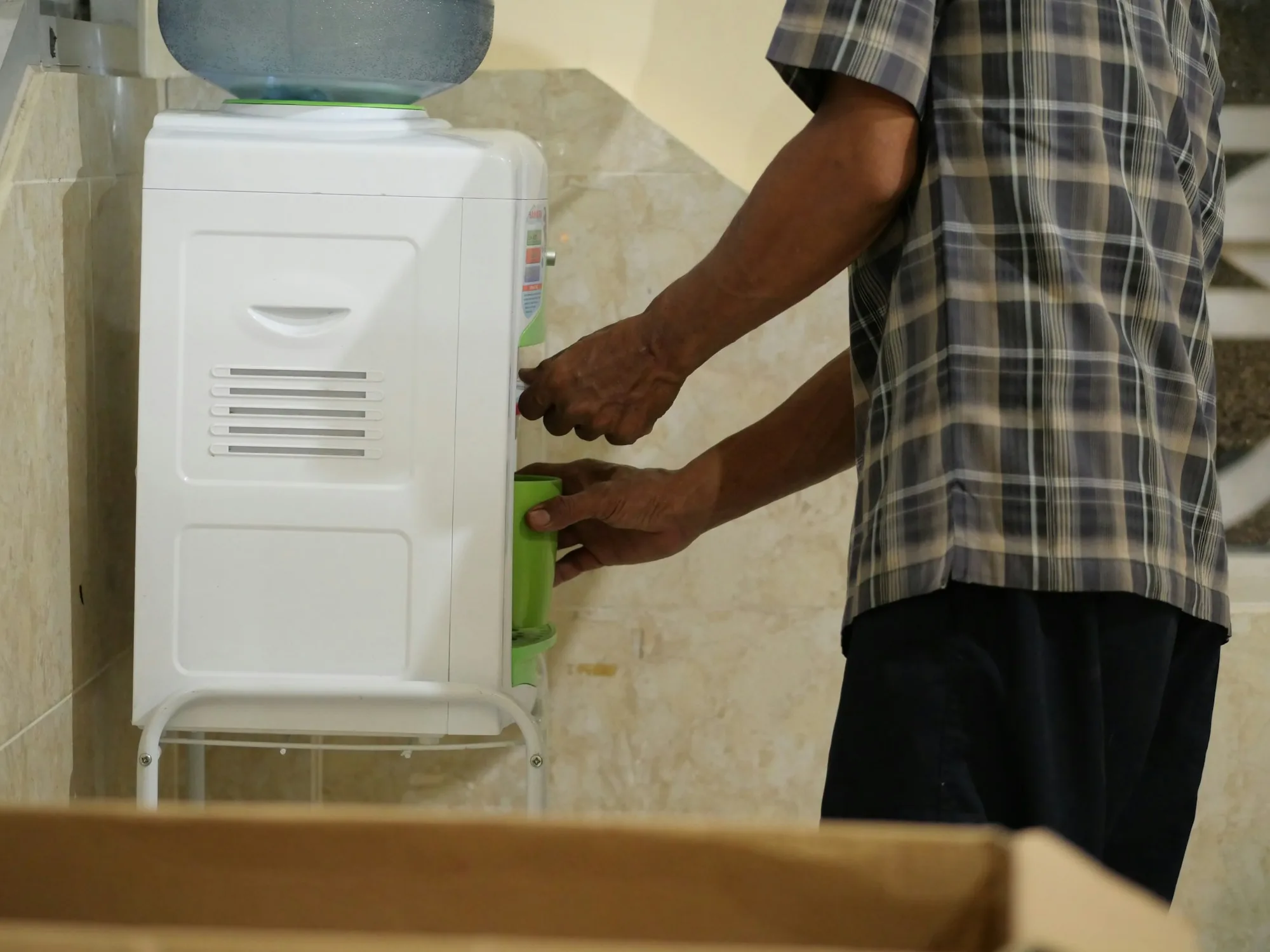 Hands fitting the spout on a clean drinking water dispenser