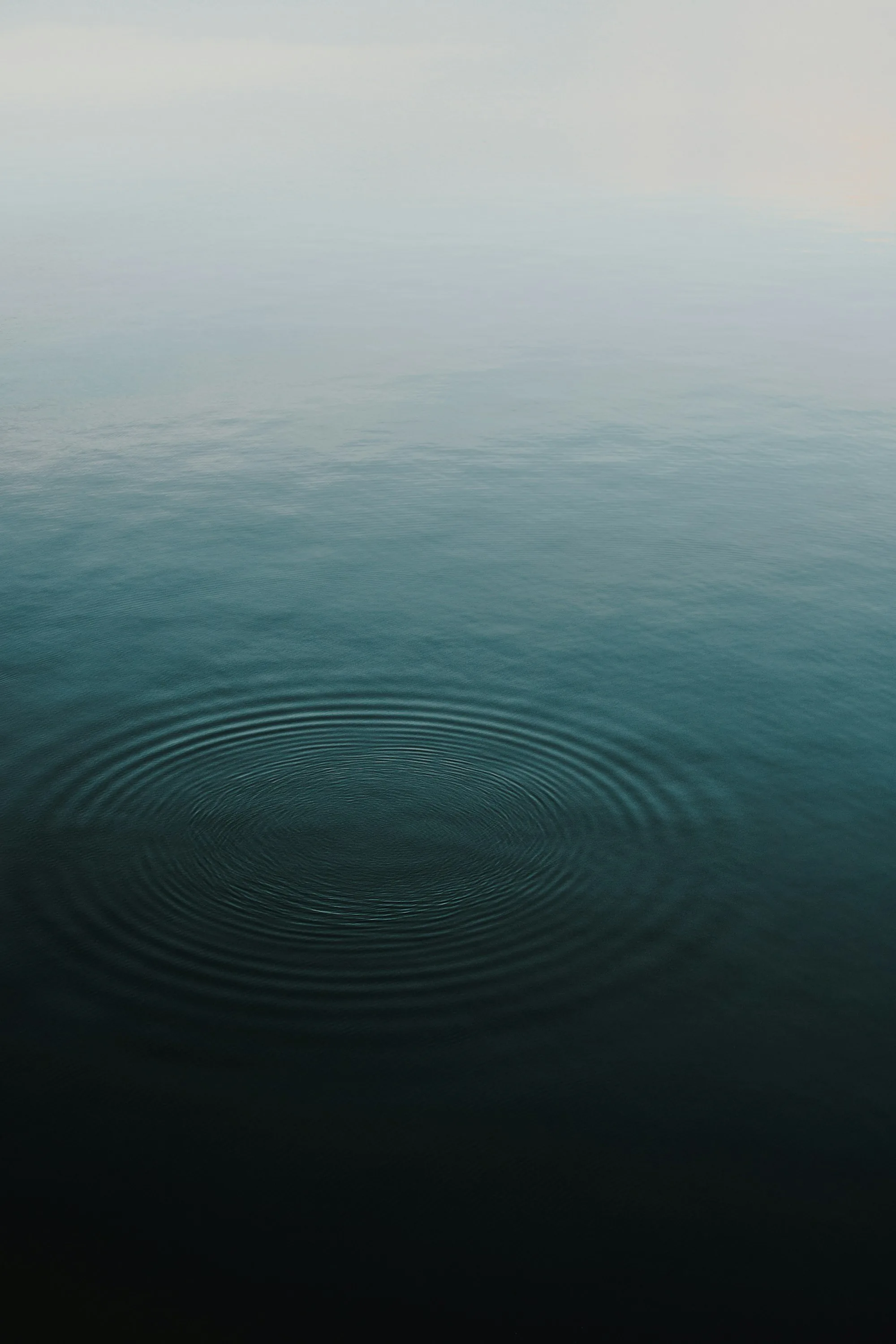 Calm still water surface with soft daylight reflections