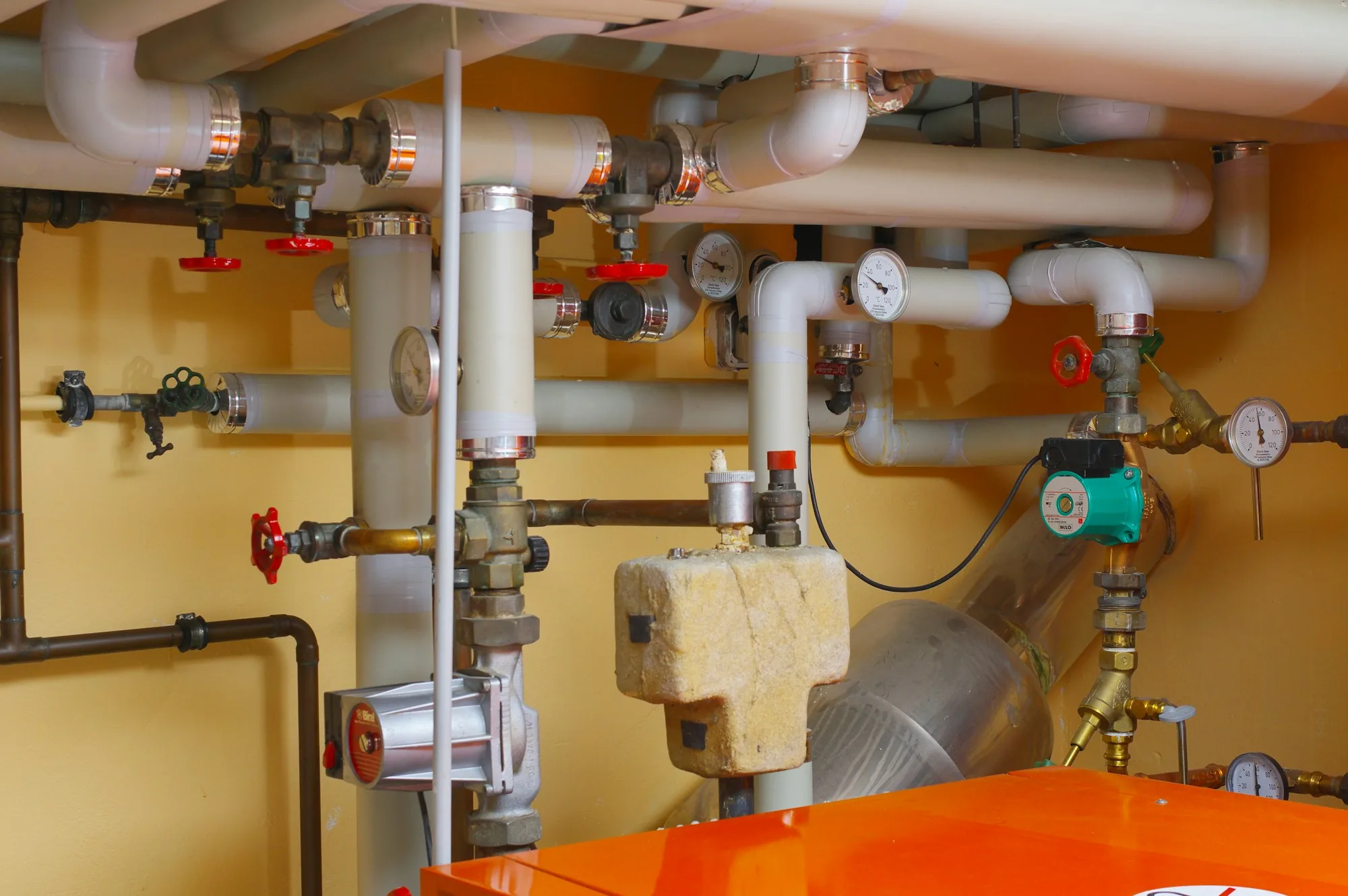 Water filter housings and copper pipework on a utility room wall