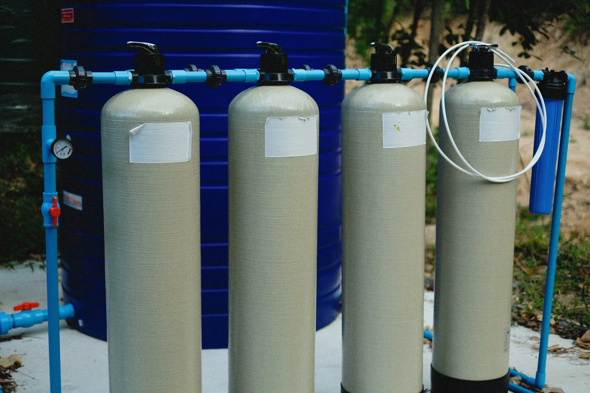 Whole-house water filtration tank installed on a residential main water line in a basement utility space
